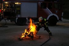 Übungsleiter Markus Würzburger demonstriert die ''dynamische Strahlrohrführung'' an einem Lagerfeuer.